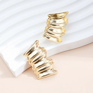 Vue détaillée de grandes boucles d'oreilles dorées avec un design ondulé plissé artistique
