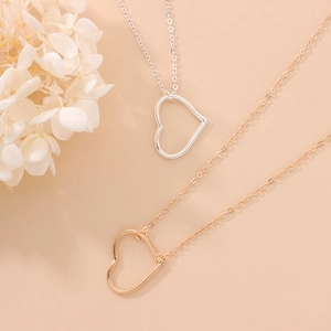 Minimalist gold and silver heart pendant body chains shown against a soft beige background