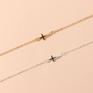 Gros plan détaillé des colliers avec pendentif croix minimaliste en finitions or et argent