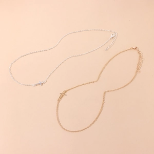 Détails de colliers avec pendentif croix minimaliste en finitions or et argent et fermoir mousqueton