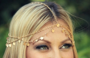 Detail of bohemian gold layered head chain with shiny sequins and wave fringe on model