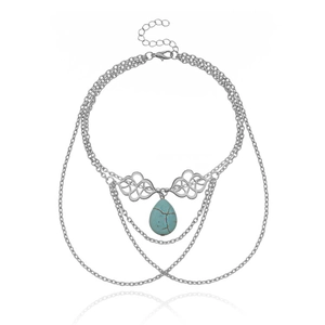 Λεπτομέρεια ασημένιας αλυσίδας μπράτσου boho με τυρκουάζ μενταγιόν και διάτρητα μεταλλικά στοιχεία