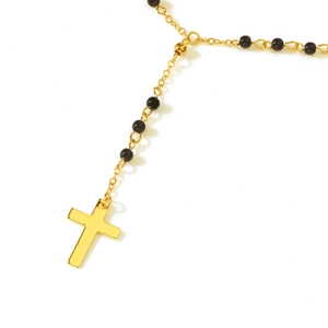 Detail of long tassel necklace featuring black turquoise beads and gold cross pendant