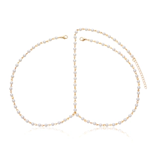 Detailed view of handmade pearl body chain with golden metal links and adjustable clasp