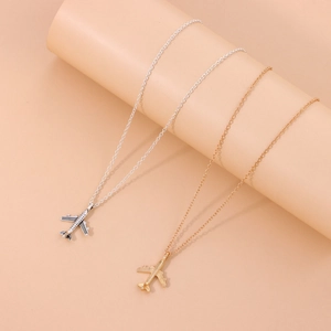 Collar con colgante de avión en plata y oro sobre elegante soporte para joyería fina