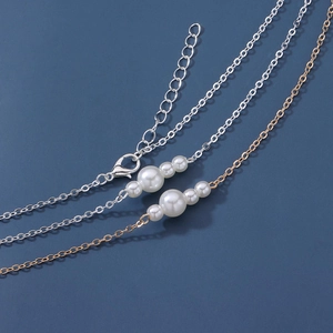 Détail de chaînes de taille ajustables en or et argent avec trois perles blanches élégantes