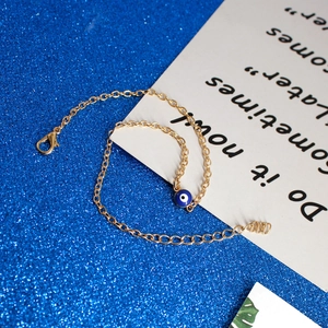 Close-up of golden Evil Eye bracelet featuring adjustable lobster clasp and extension chain