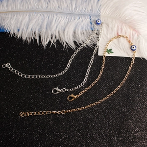 Detailed view of silver and gold evil eye charm bracelets with lobster clasp and chain