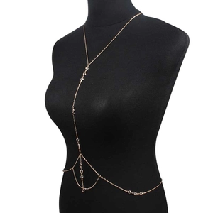 Chaîne de corps dorée élégante avec cristaux sur un mannequin noir de face
