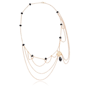 Close-up of gold star head chain with multilayer chains and black beads detailing