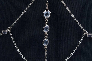 Chaîne de corps dorée élégante avec accents de cristal sur tissu bleu foncé