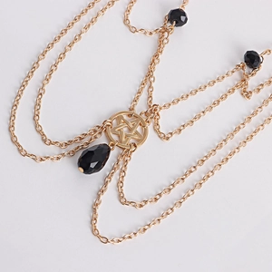 Detail of gold multi-layer head chain featuring pentagram pendant and black crystal teardrop