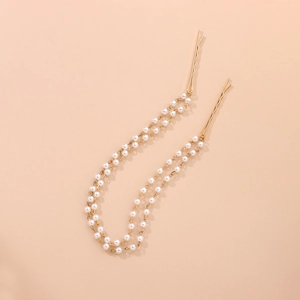 Detailed macro view of handmade faux pearl chain hair clips in elegant golden metal finish