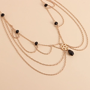 Close-up of layered gold alloy chain featuring black beads and pentagram star pendant