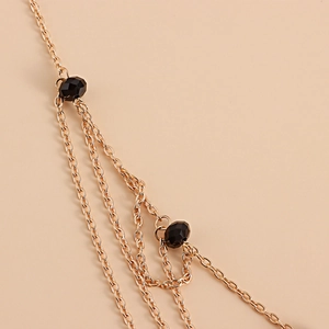 Detail view of layered gold star head chain with elegant black faceted crystal beads
