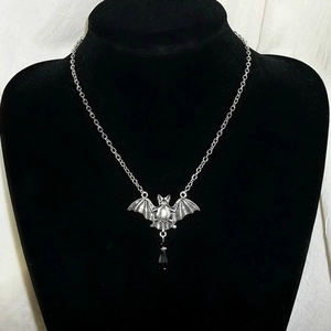 Gothic vleermuis hanger ketting in zilverkleur met zwarte kraal op een halsmodel