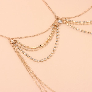 Detailed view of layered gold chain hair accessory with crystal accents and square blocks