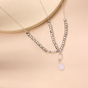 Silver bead chain necklace featuring a soft pink teardrop pendant in a modern geometric style