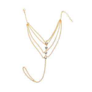 Détail d'une chaîne de corps dorée multicouche avec des accents de strass sur fond blanc