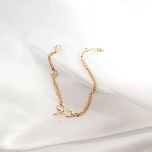 Details des goldenen Schleifenarmbands mit doppelter Kette und verstellbarem Verschluss