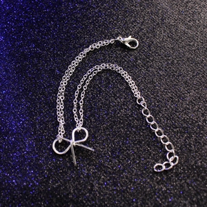 Detailaufnahme des silbernen Schleifen-Armbands mit Karabinerverschluss auf glitzerndem Grund