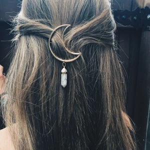 Golden moon hair clip with white hexagonal marble stone pendant on dark brown hair