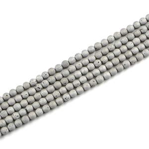 Macro detail of 8mm grey volcanic stone beads with natural porous texture and matte finish