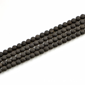 Macro detail of 8mm natural black lava stone beads with porous texture for DIY jewelry