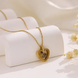 Macro shot of gold heart necklace pendant with inlaid crystals and projection stone