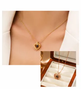 Macro shot of rose gold heart projection necklace with crystal accents in a jewelry box