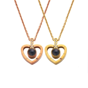 Golden and rose gold heart projection necklace with small diamonds and 1-5 scale engraving