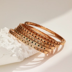 Set di cinque bracciali in acciaio oro rosa con zirconi colorati su una pietra
