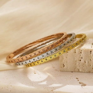 Dettaglio di tre braccialetti a quadri con zirconi in oro, argento e oro rosa lucido
