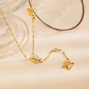 Elegant gold titanium necklace featuring butterfly pendants with white mother of pearl