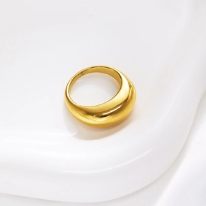Detailed close-up of golden polished domed ring on white silk background