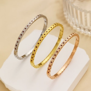 Tre bracciali in acciaio inossidabile oro, argento e rosa con zirconi rossi incastonati