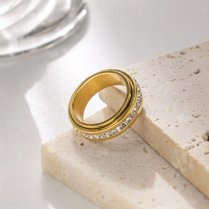 Detail of a rotating gold stainless steel ring featuring inlaid sparkling zircon stones