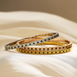 Macro di tre braccialetti sovrapposti in oro argento e oro rosa con zirconi verdi
