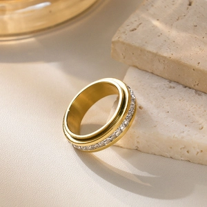 Macro shot of gold stainless steel spinning ring with cubic zirconia on stone base