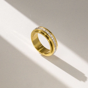 Golden rotatable stainless steel ring with sparkling zircon inlays for stress relief