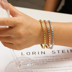 Dettaglio di tre bracciali tennis in oro, argento e oro rosa con zirconi verdi lucidi