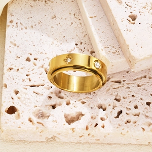 Macro detail of a gold titanium rotating heart ring with starburst engraving and zircons