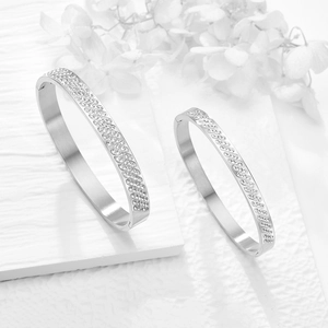 Dettaglio di bracciali in acciaio argento con numeri romani e pavé di cristalli