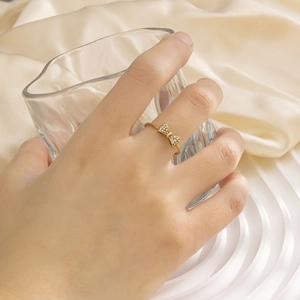Detailansicht eines goldenen Schleifenrings mit Strasssteinen und gedrehter Ringschiene