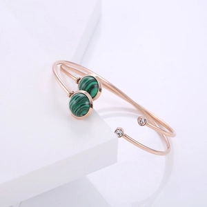 Dettaglio di un bracciale in oro rosa con pietre di malachite verde e piccoli diamanti