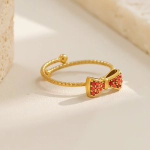 Nahaufnahme eines goldenen Schleifenrings mit roten Zirkonia und Strukturring