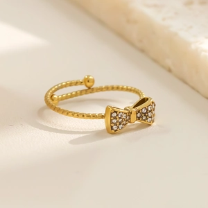Detailansicht eines goldenen Schleifenrings mit Zirkonia und gedrehter Seiltextur