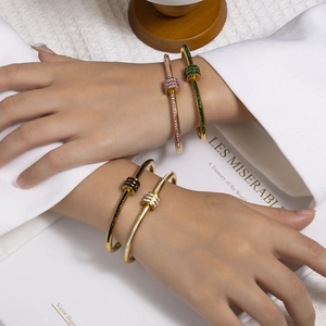 Detailansicht von vier goldfarbenen Armbändern mit farbigen Zirkoniasteinen im Set