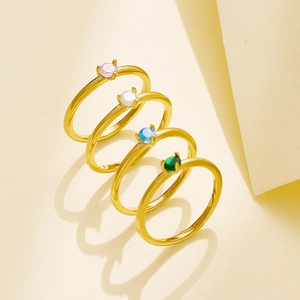 Set de cuatro anillos de acero de titanio dorado con piedras rosa, blanca, azul y verde