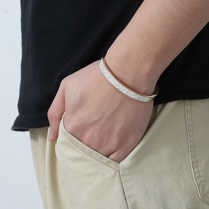 Rose gold plated titanium steel bangle with rows of zircon stones shown on a wrist